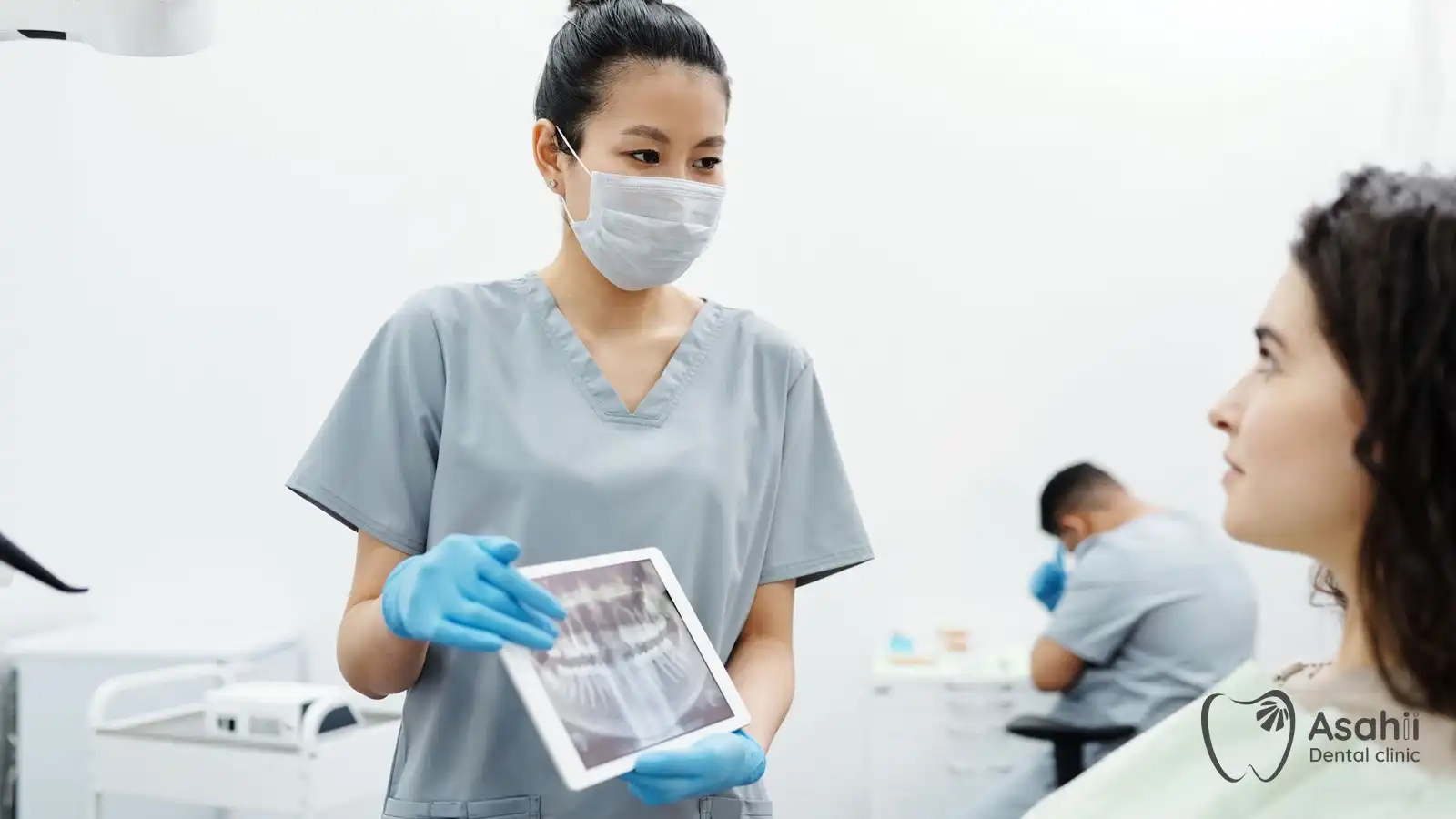 The dentist shows the patient an X-ray while explaining the implant procedure