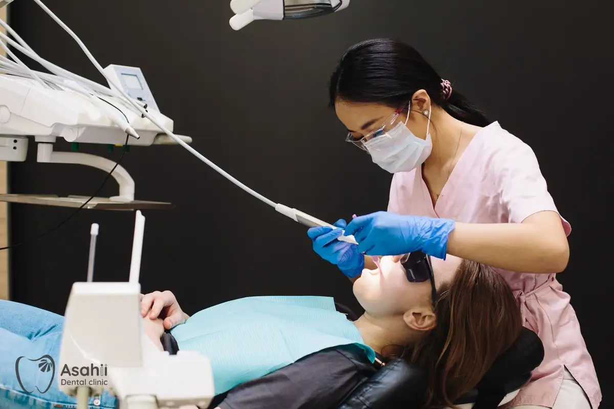 The dentist removes tartar and cleans the patient's teeth in the dental chair