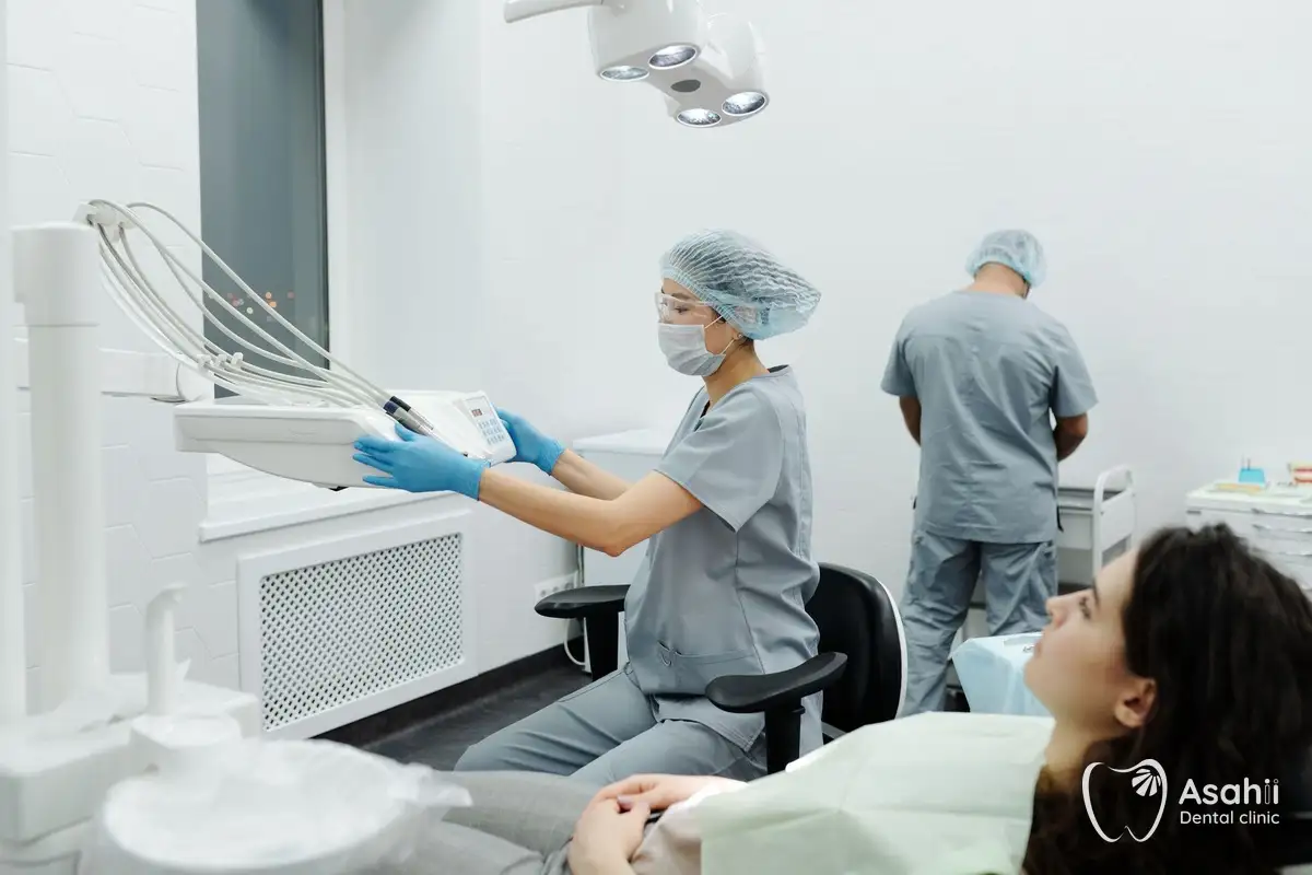 The dentist prepares the equipment for an in-clinic whitening session