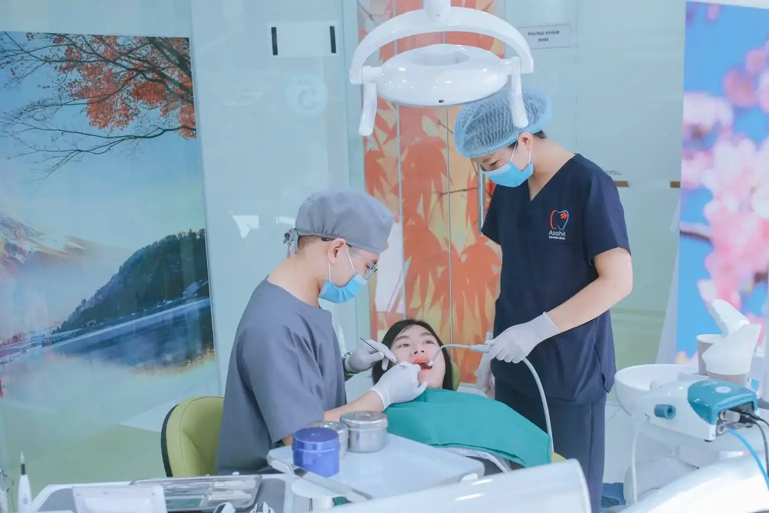 Bác sĩ và trợ thủ Asahii điều trị cho khách hàng trên ghế nha