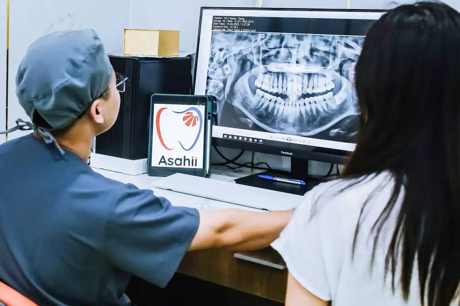 Bác sĩ Asahii xem phim X-quang toàn hàm cùng khách hàng trước khi lên kế hoạch